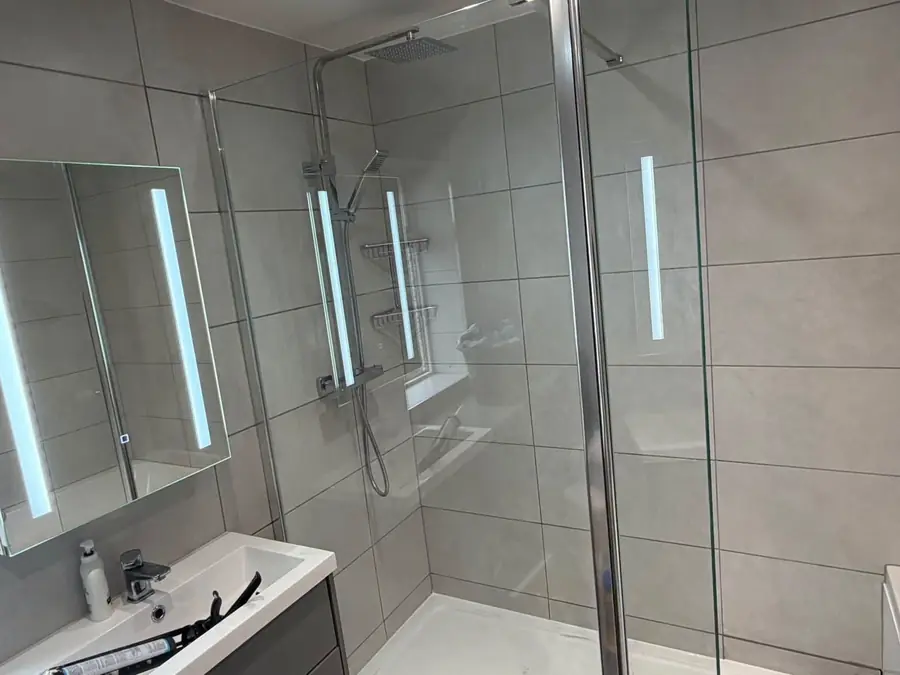 Tiled shower enclosure with chrome thermostatic shower and LED mirror
