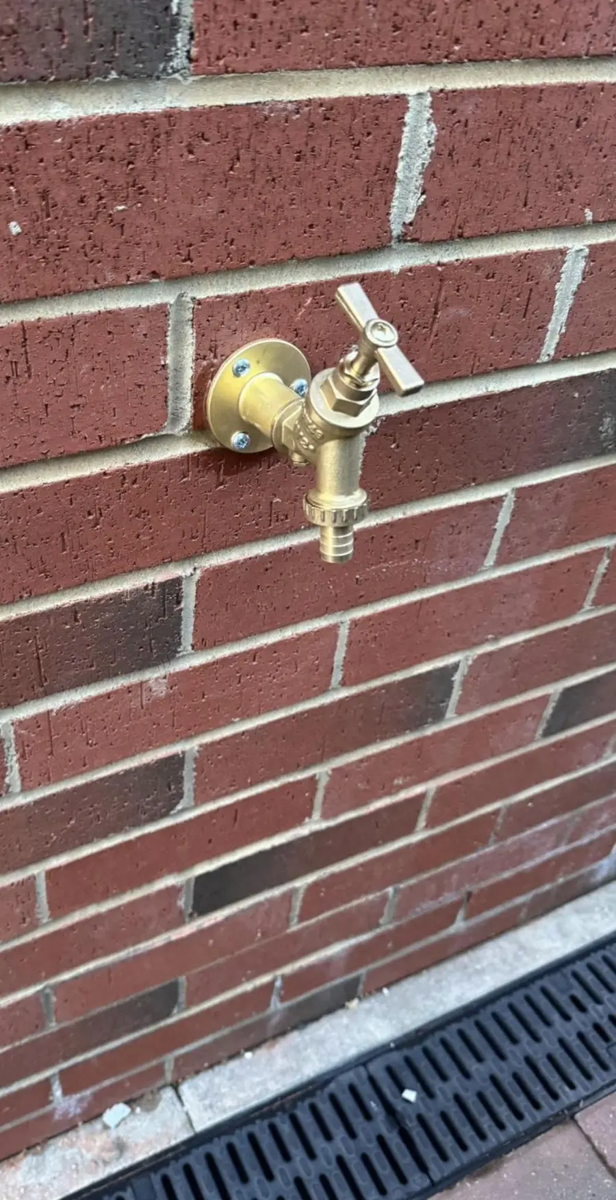 Brass outside tap fitted to brick wall, Teesside